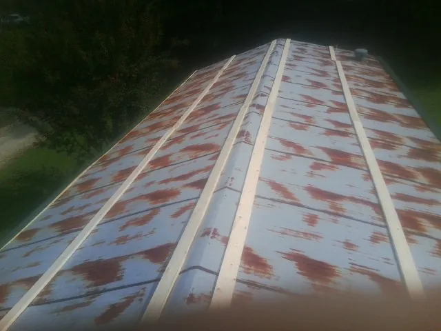 Rusted metal roof panels with new wood purlins before replacement — Storm Damage Roof Repair in Fort White by Roofing Brothers