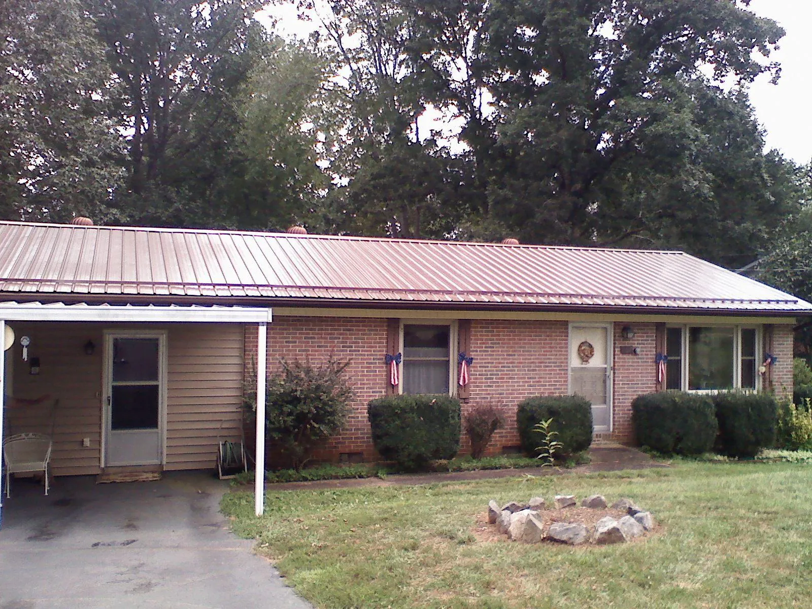 Bronze metal roof and carport on a brick ranch home — Roof Repair work by our crew in Fort White